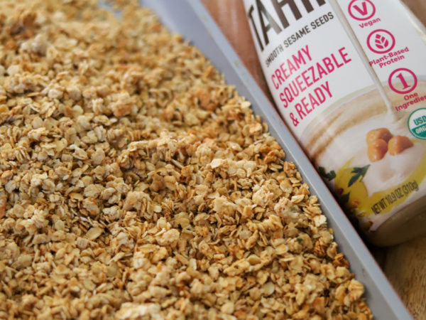 Golden brown tahini crumble bake in a glass dish, featuring a crunchy topping.
