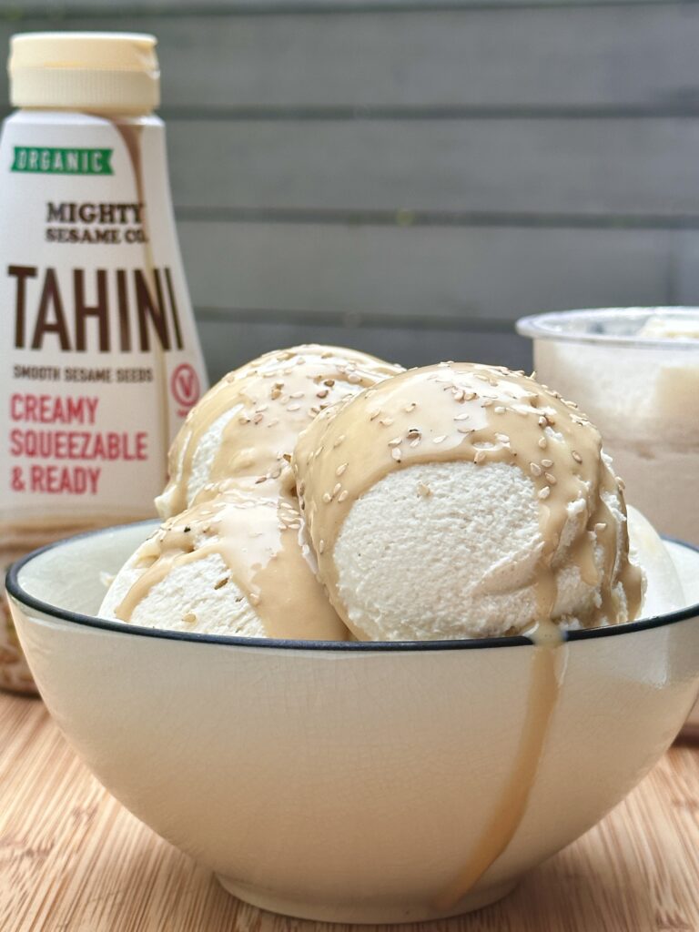 homemade ice cream with tahini served in a glass bowl with tahini drizzled on top