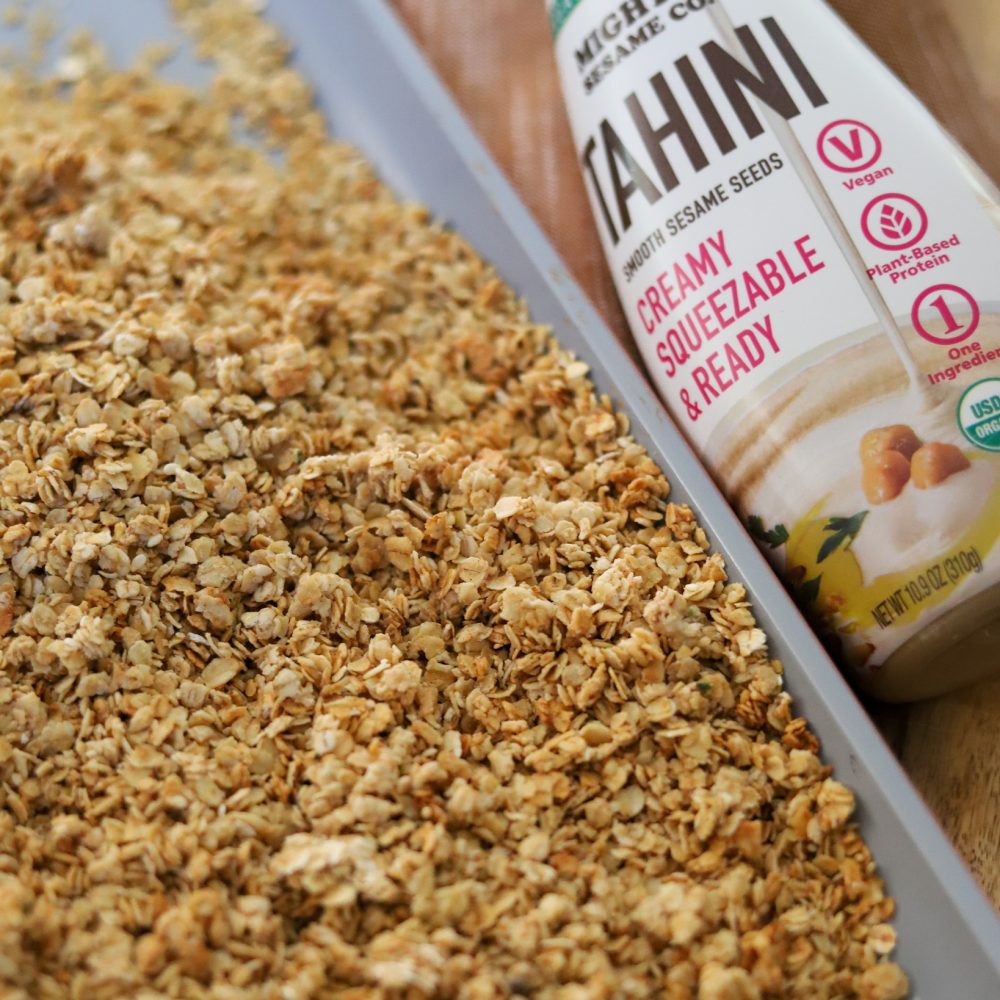 Golden brown tahini crumble bake in a glass dish, featuring a crunchy topping.